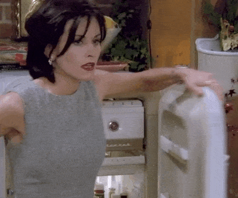Une femme ouvre un frigo.