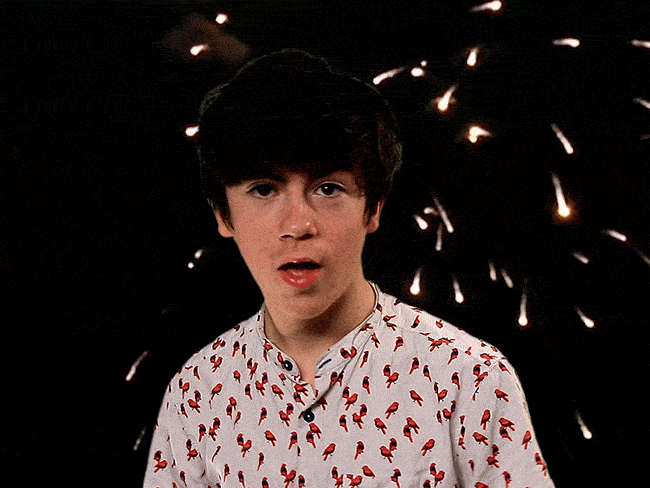 Fireworks and a happy young man winking.