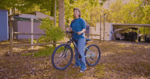A girl is astride a bicycle.