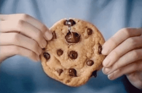Un homme coupe un cookie en deux.