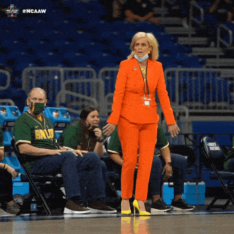 Une femme coache sur un parquet de basket.